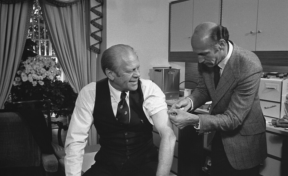 President Gerald Ford sits while a clinician gives him an upper-arm injection in 1976.