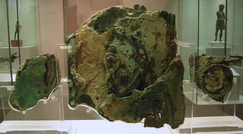 Corroded fragments of the Antikythera mechanism displayed in a museum case
